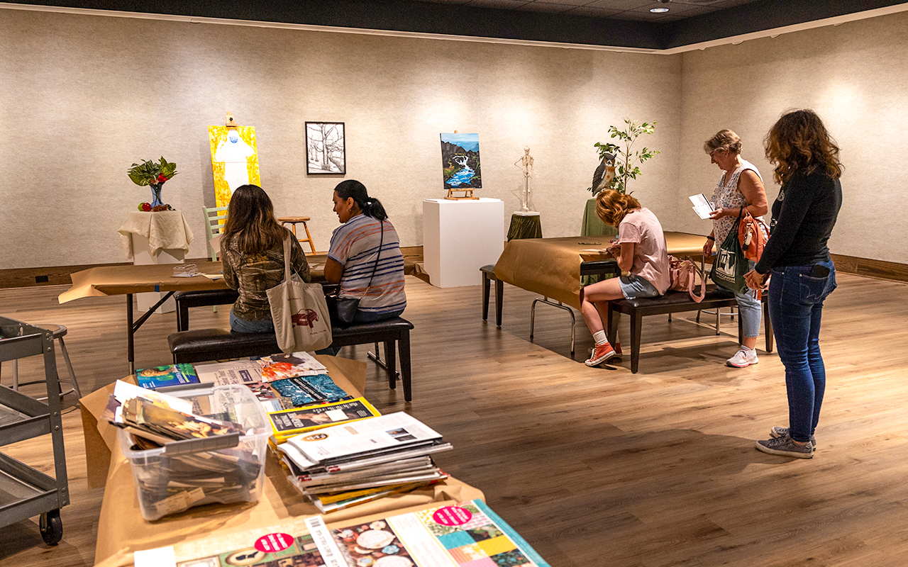 Prospective students and parents in the gallery doing an art-related activity
